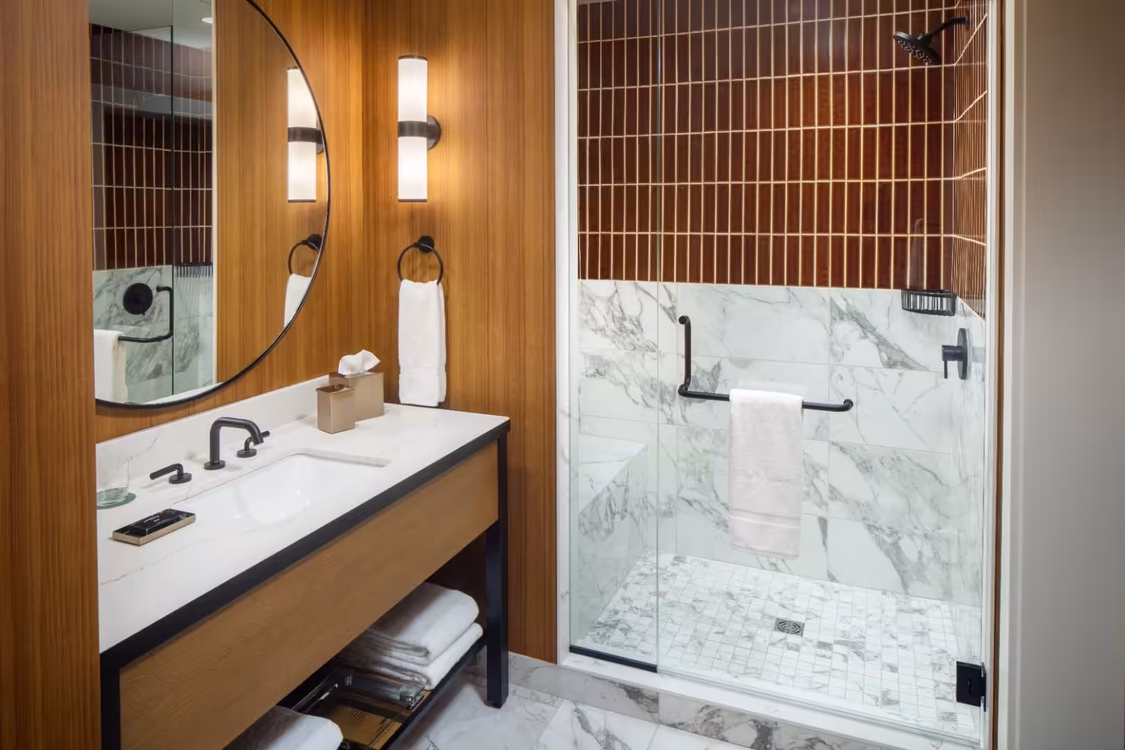 Modern hotel bathroom with marble vanity and glass shower