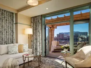 Elegant hotel suite living area with balcony access and city views