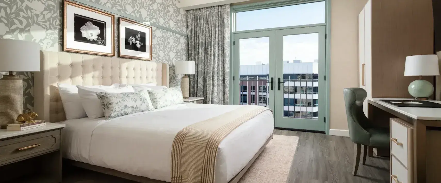 Spacious deluxe guestroom at The Benson Hotel with plush bed and sitting area